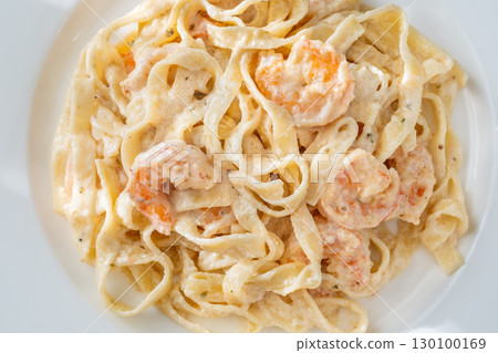 Creamy fettuccine shrimp pasta white plate savory sauce gourmet flavor Creamy fettuccine shrimp pasta white plate savory sauce gourmet flavor 130100169