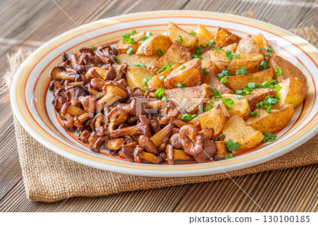 Fried potatoes chanterelle mushrooms seasoned paprika rustic wooden table plate Fried potatoes chanterelle mushrooms seasoned paprika rustic wooden table plate 130100185
