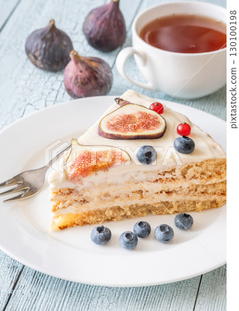 Cake wedge topped berries figs served tea cup rustic cozy setting 130100198