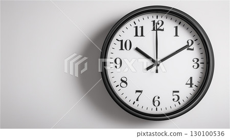特寫：白色牆上掛著一個黑色框架的簡易掛鐘，顯示時間為 10:10。 130100536