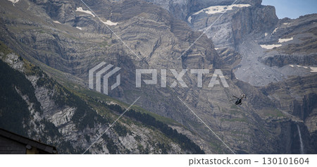 Helicopter conducting police operations in Cauteret, Pyrenees near Gavarnie under overcast skies Helicopter conducting police operations in Cauteret, Pyrenees near Gavarnie under overcast skies 130101604