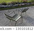Green traditional chairs in Parisian public park to sit and relax with multicoloured flower bed on background of Luxembourg Gardens, Jardin de Luxembourg, in Paris, empty typical chairs scenic view 130101812