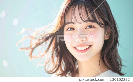 Smiling young woman in studio with her hair blowing in the gentle breeze Smiling young woman in studio with her hair blowing in the gentle breeze 130102222