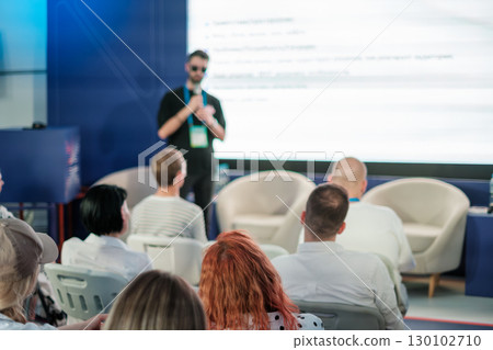 Speaker presenting to audience during conference with focus on attendees 130102710