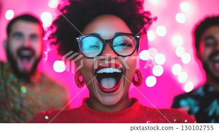 group of friends celebrating joyfully with bright lights in background. woman in front is smiling widely, showcasing her excitement and happiness 130102755