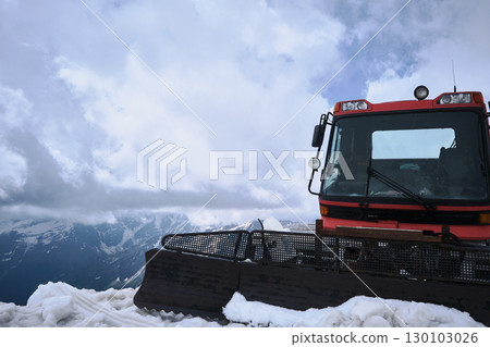 Red Snow Groomer on Snowy Mountain Ridge under Cloudy Sky 130103026