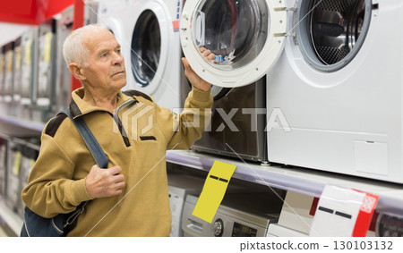 elderly man choosing washing machine in showroom of electrical appliance store 130103132