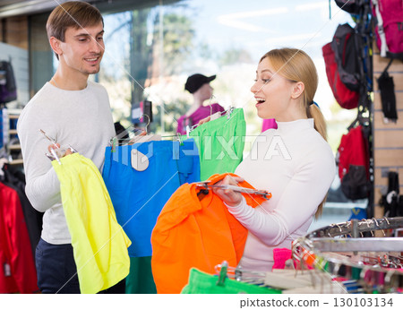 Married couple choosing summer shorts together in clothing store Married couple choosing summer shorts together in clothing store 130103134