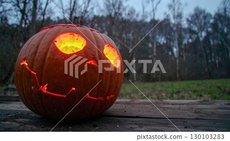 Glowing Halloween pumpkin lantern with scary face, traditional autumn symbol, seasonal spooky background for holiday celebration design 130103283