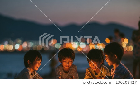 Smiling children gather around hand-held fireworks on the beach 130103427