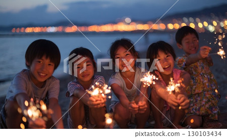 Smiling children lined up on the beach holding fireworks 130103434