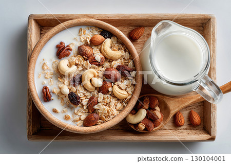 Hotel Breakfast Styles. Top view of a tray of muesli in nuts on a bowl and milk jug on a white background. Classic breakfast. 130104001