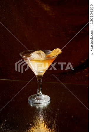 Elegant cocktail with dried citrus and ice cube against dark sparkling background 130104169