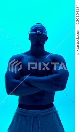 Shirtless male model in futuristic visor with crossed arms on cyan background 130104184