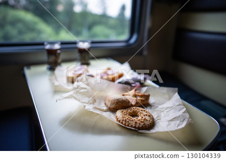 Train food pastry and tea on table in long distance car. Travel meal, railway snack, onboard meal 130104339