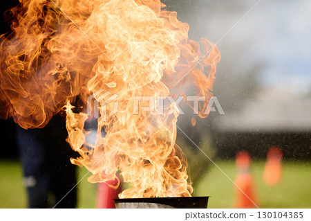Blazing Flames. Firefighters practice controlling an outdoor fire with extinguishers Blazing Flames. Firefighters practice controlling an outdoor fire with extinguishers 130104385