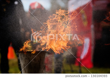 Fiery Display. Firefighters practice controlling an outdoor fire with extinguishers Fiery Display. Firefighters practice controlling an outdoor fire with extinguishers 130104393