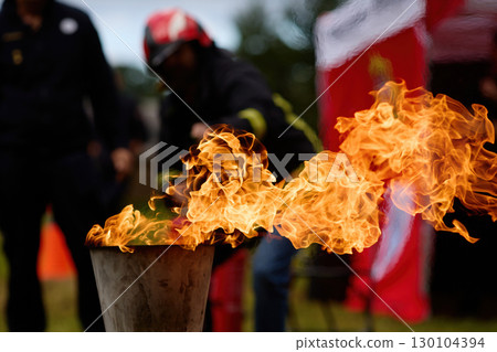 Vibrant Flame. Firefighters practice controlling an outdoor fire with extinguishers Vibrant Flame. Firefighters practice controlling an outdoor fire with extinguishers 130104394