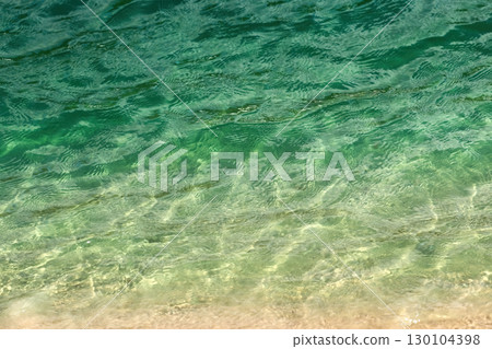 Serene Shoreline. Calm turquoise waters gently meet the sandy beach. Serene Shoreline. Calm turquoise waters gently meet the sandy beach. 130104398
