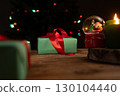 Christmas Gifts and Decorations on Rustic Wooden Table at Night 130104440