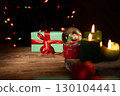 Christmas Gift, Candles, and Snow Globe on Wooden Surface During Nighttime 130104441