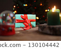 Holiday Gift With Candle and Snow Globe on Table Indoors 130104442