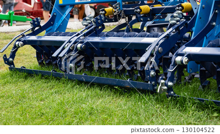 Agricultural machinery close-up with metal components and red frame. 130104522