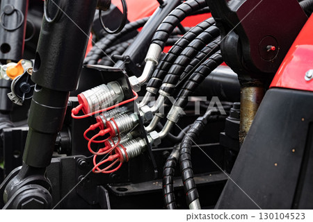 Close-up of hydraulic hoses and connectors on machinery equipment. Close-up of hydraulic hoses and connectors on machinery equipment. 130104523