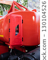 Close-up of a red fire extinguisher container on an industrial vehicle. 130104526