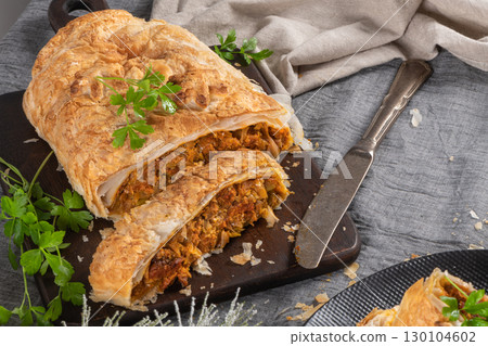 Puff pastry vegetable roll on kitchen table with christmas decorated 130104602
