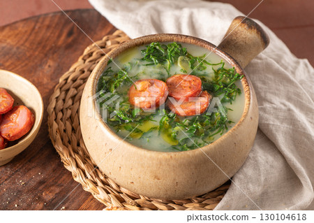 Caldo verde popular soup in Portuguese cuisine. Traditional ingredients for caldo verde are potatoes, onion, garlic, collard greens, chorizo , olive oil and salt. Is a comfort soup and is typically 130104618