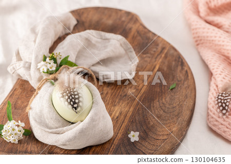 Stylish Easter brunch table setting with egg in easter bunny napkin. 130104635