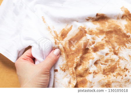 Woman showing large foundation stain on white t-shirt Woman showing large foundation stain on white t-shirt 130105018