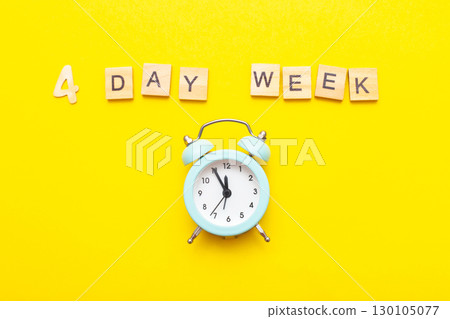 inscription four day week making by wooden cubes on yellow background inscription four day week making by wooden cubes on yellow background 130105077
