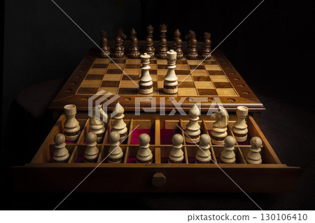 Chess pieces of wood on a beautiful chessboard. A puzzle game with tricky combinations that requires planning and thinking. Chess pieces of wood on a beautiful chessboard. A puzzle game with tricky combinations that requires planning and thinking. 130106410