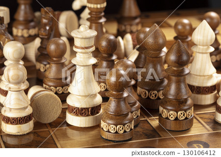 Chess on a dark background. A puzzle game with tricky combinations that requires planning and thinking. 130106412