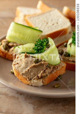 Open sandwiches with pate, cucumber, capers, and parsley. 130106838
