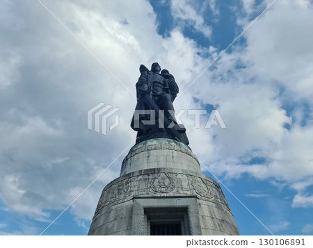 Berlin, Germany - August 1, 2025: Soviet War Memorial, Treptower Park, bronze statue of a Soviet soldier with a sword holding a German child, standing over a broken swastika Berlin, Germany - August 1, 2025: Soviet War Memorial, Treptower Park, bronze statue of a Soviet soldier with a sword holding a German child, standing over a broken swastika 130106891