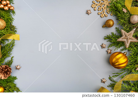 Golden Christmas Decorations with Greenery on Light Background 130107460