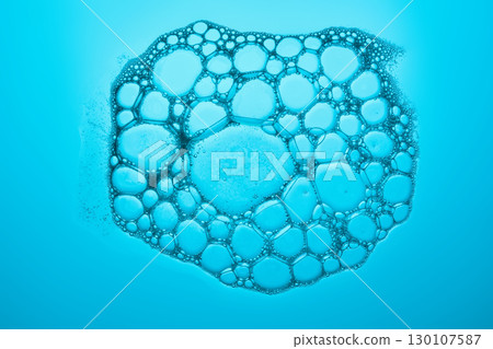 The texture of soap bubbles and foam in close-up on a blue background. 130107587