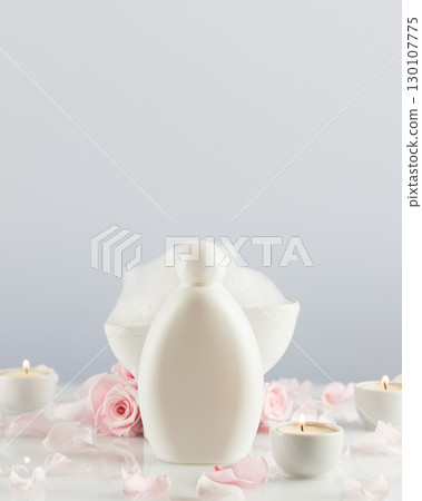 Mock up of bath beauty product. Spa relax composition with white cosmetic bottle, soap foam, candles and rose petals on white table. Wellness and skin care treatment. Concept of me time and self care 130107775