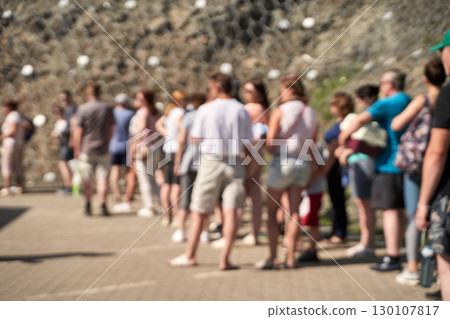 Blurred crowd image of diverse caucasian adults and teens outdoors in line 130107817