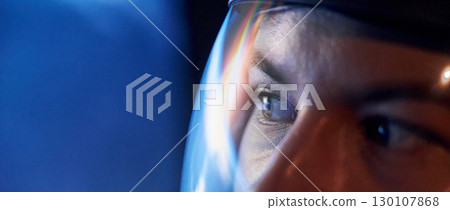 Close up view of woman in glassed space helmet against blue background 130107868
