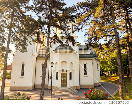 Orthodox church with sun rays shining through pine trees, Belgrade, Serbia. Religion, spirituality, heritage, and cultural tradition. Orthodox church with sun rays shining through pine trees, Belgrade, Serbia. Religion, spirituality, heritage, and cultural tradition. 130107993