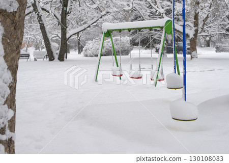 Snow-Covered Playground Swings in Winter Urban Park Snow-Covered Playground Swings in Winter Urban Park 130108083