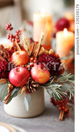 Vibrant autumn floral arrangement featuring red apples, seasonal flowers, and natural elements, creating a warm and inviting centerpiece for fall decor 130108179