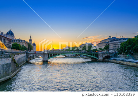 Paris cityscape of historic city center with Pont Notre-Dame bridge across Seine river, de la Cite island and Rive Droite with old buildings on sunset twilight, Paris city evening view, France 130108359