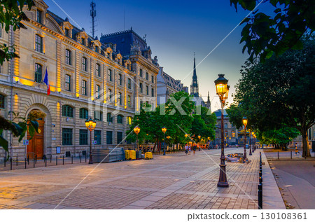 Paris street with lamp lights on sunset twilight in historic city center, Paris cityscape evening view, Place Louis-Lepine square with prefecture of police building on de la Cite island, France Paris street with lamp lights on sunset twilight in historic city center, Paris cityscape evening view, Place Louis-Lepine square with prefecture of police building on de la Cite island, France 130108361