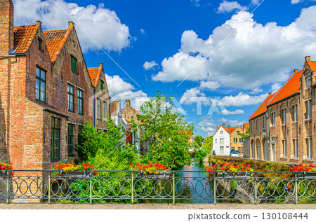 Ezelbrug Donkey Bridge across Augustijnenrei Augustine water canal, bridge with flowers on fence, green trees and old houses in Brugge old town, Bruges city historic centre, Flemish Region, Belgium Ezelbrug Donkey Bridge across Augustijnenrei Augustine water canal, bridge with flowers on fence, green trees and old houses in Brugge old town, Bruges city historic centre, Flemish Region, Belgium 130108444