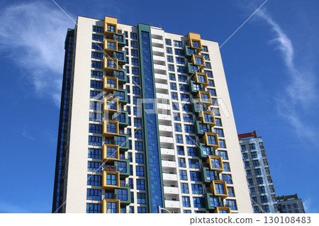 Gazing upward at three towering buildings set against a clear blue sky 130108483
